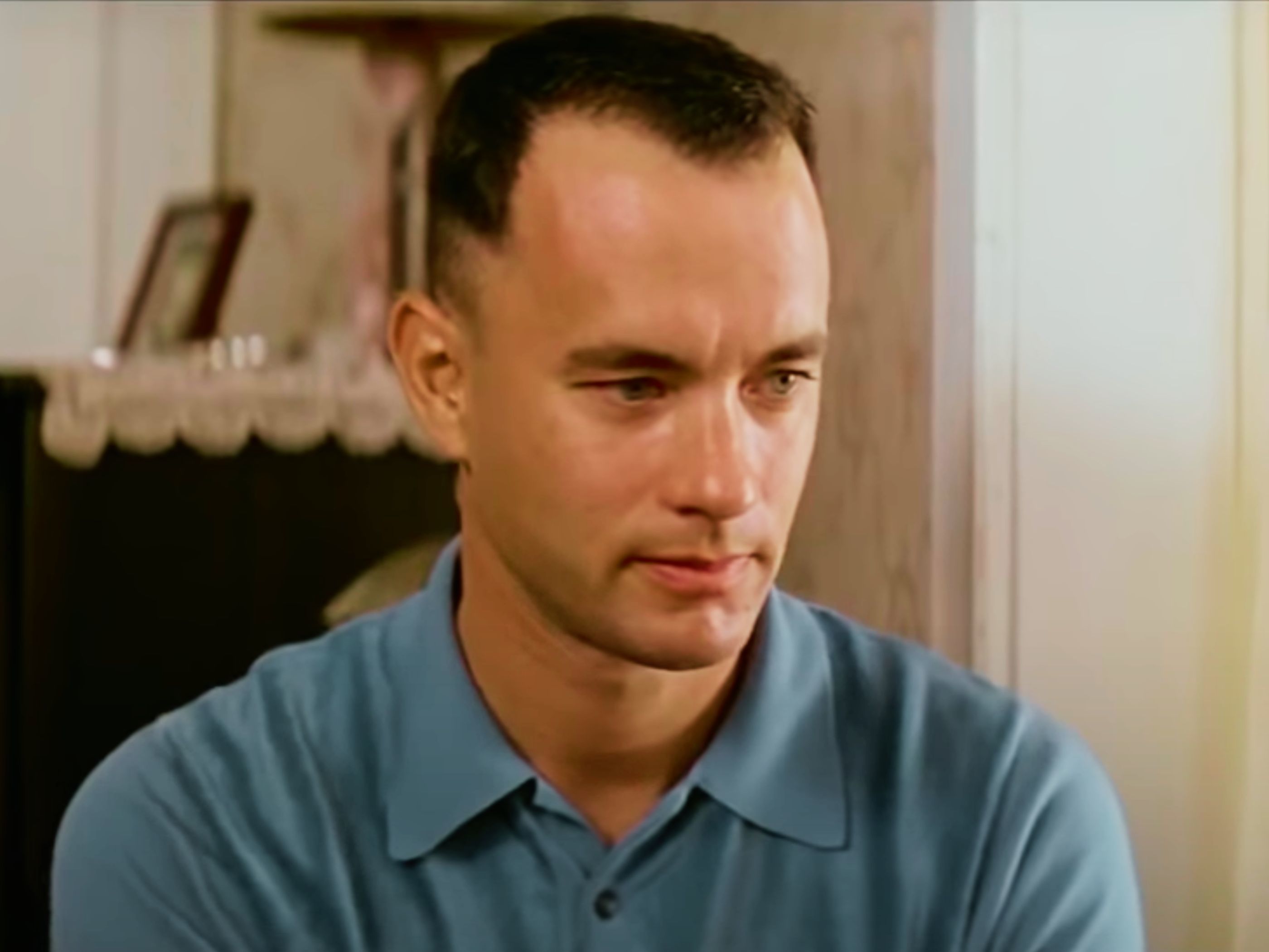 Forrest Gump en la habitación de su madre con camisa azul