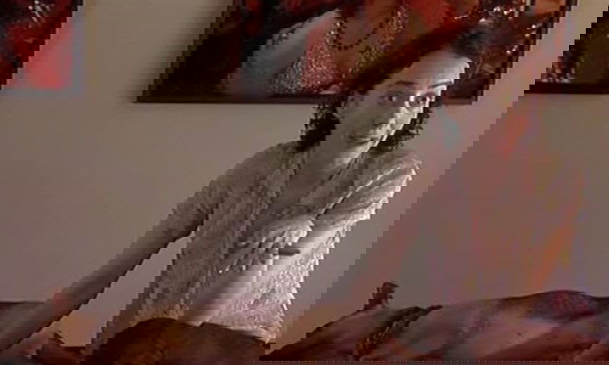 Perro tumbado en el sofá junto a una mujer, que habla