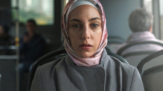 Mulher com véu na cabeça e expressão enigmatica.