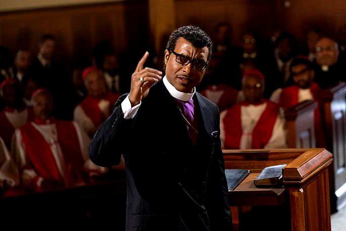 Pastor falando durante a missa e fieis escutando
