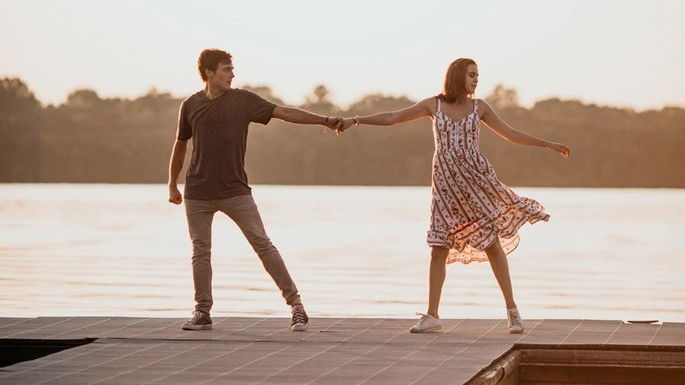 Casal de jovens dançando no pôr-do-sol