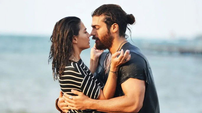 Casal se beijando na praia.