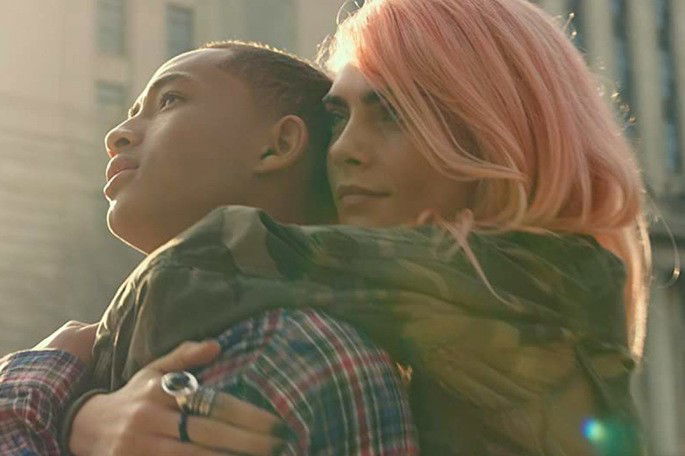 Garota de cabelo rosa abraçando um garoto.