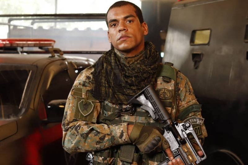 Homem com uniforme do BOPE, olhando em frente com uma expressão séria.