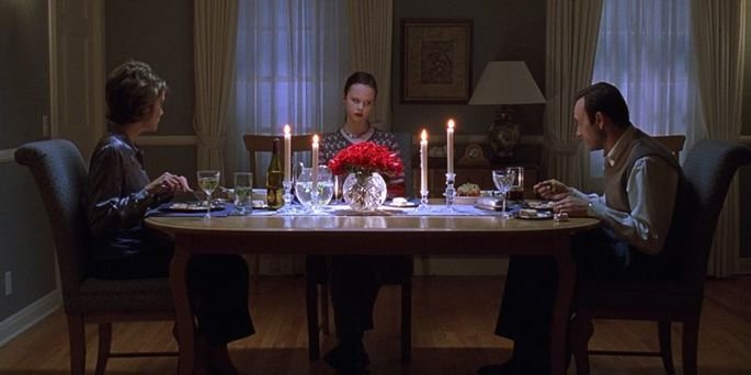 Família de Lester sentada na mesa, jantando.