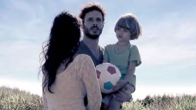 Mulher e homem que segura uma criança no colo.