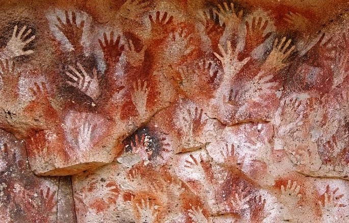 arte rupestre mostrando figuras de mãos em parede de caverna na Argentina