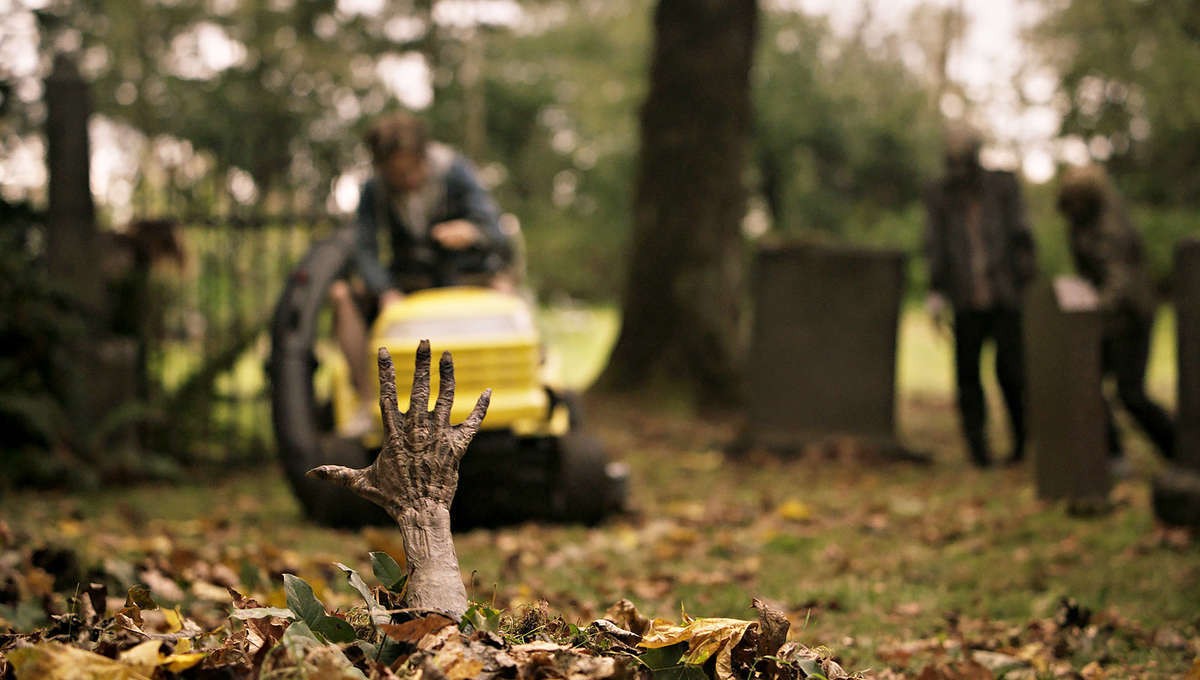 Mão de zumbi saindo da terra.