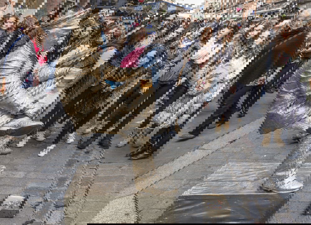 estátua viva pintada de dourado sentada em posição ilusionista