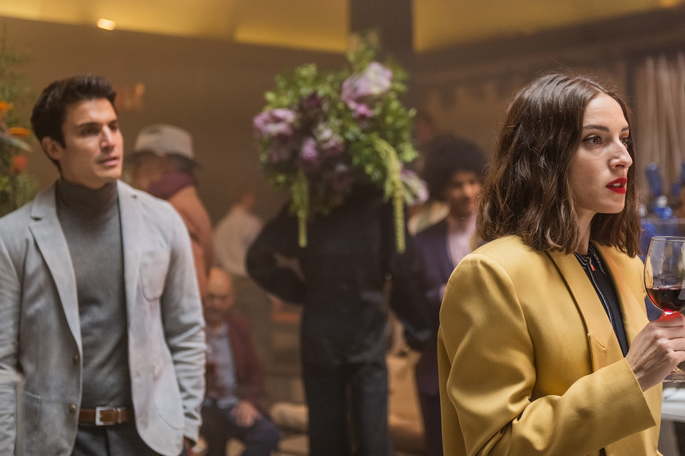 Homem numa festa, olhando para uma mulher.