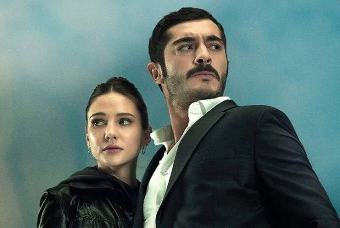 Homem de bigode protegendo uma mulher.