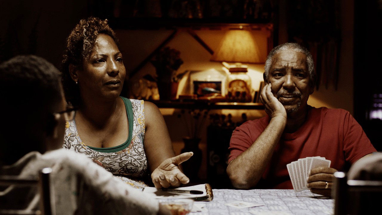 cena do filme Marte Um mostra casal em mesa de jantar conversando e jogando baralho