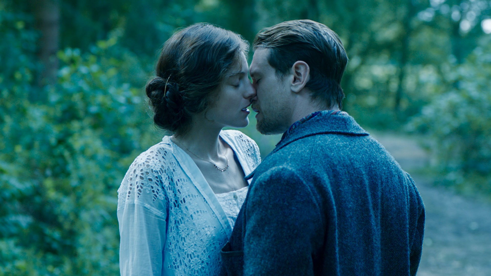 cena do filme O amante de Lady Chatterley mostra um casal se beijando na floresta