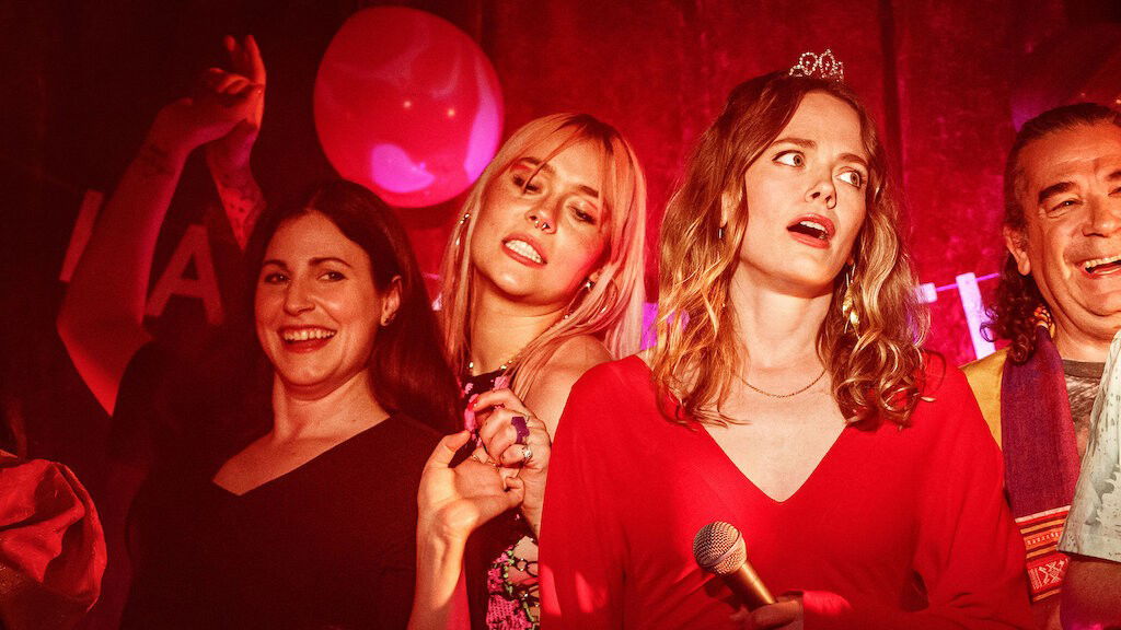 Cena do filme O ano em que comecei a vibrar por mim mostra 3 mulheres usando roupas vermelhas
