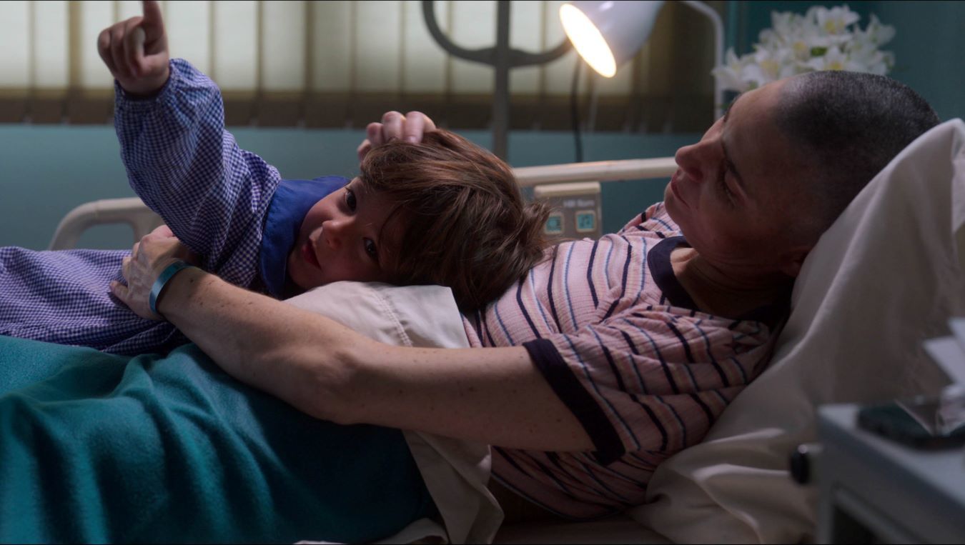 cena de O caderno de Tomy mostra uma mulher e seu filho em um leito de hospital