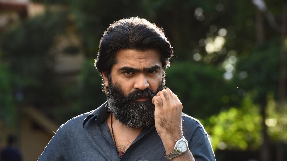 cena do filme Pathu Thala mostra um homem com barba e expressão séria
