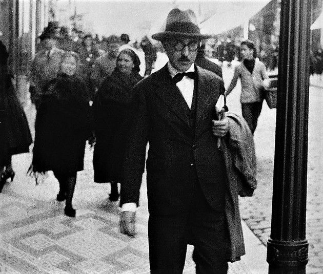 Retrato de Fernando Pessoa caminhando nas ruas de Lisboa.