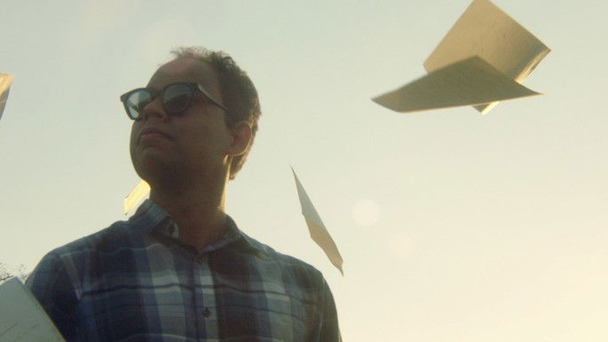 Homem de óculos, olhando para o céu.