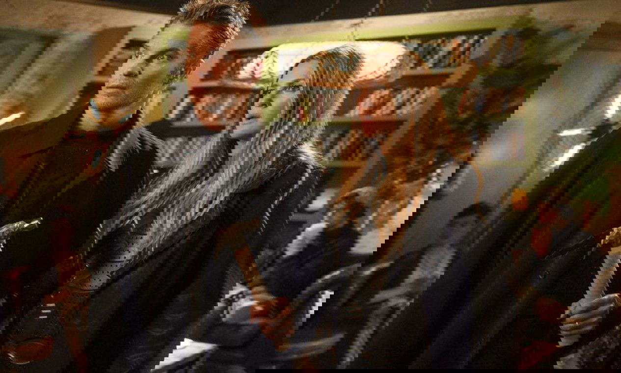 Homem segurando um martelo, com a esposa do lado.