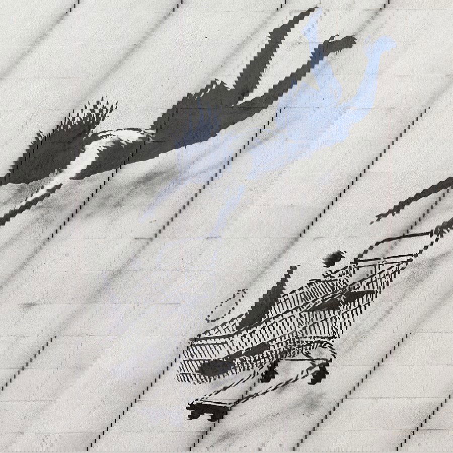 stencil de Banksy mostra mulher caindo com carrinho de comprar